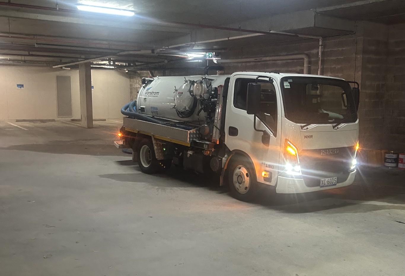Compact vacuum tanker beneath the low concrete ceiling of a car park