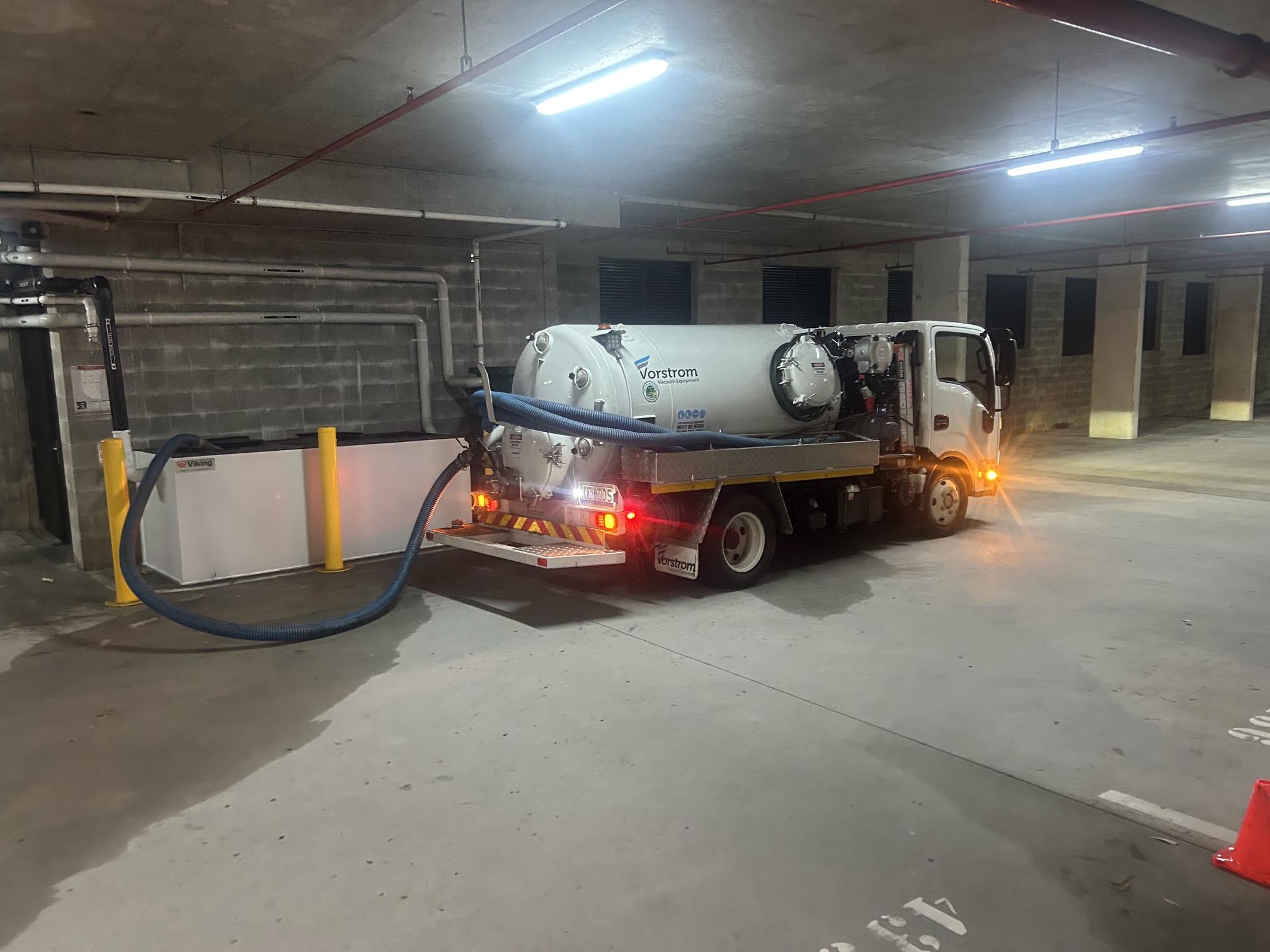 Compact vacuum tanker with its hose connected in a basement